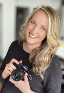 Gloucestershire wedding photographer Alicia Victoria smiling and holding her Sony camera