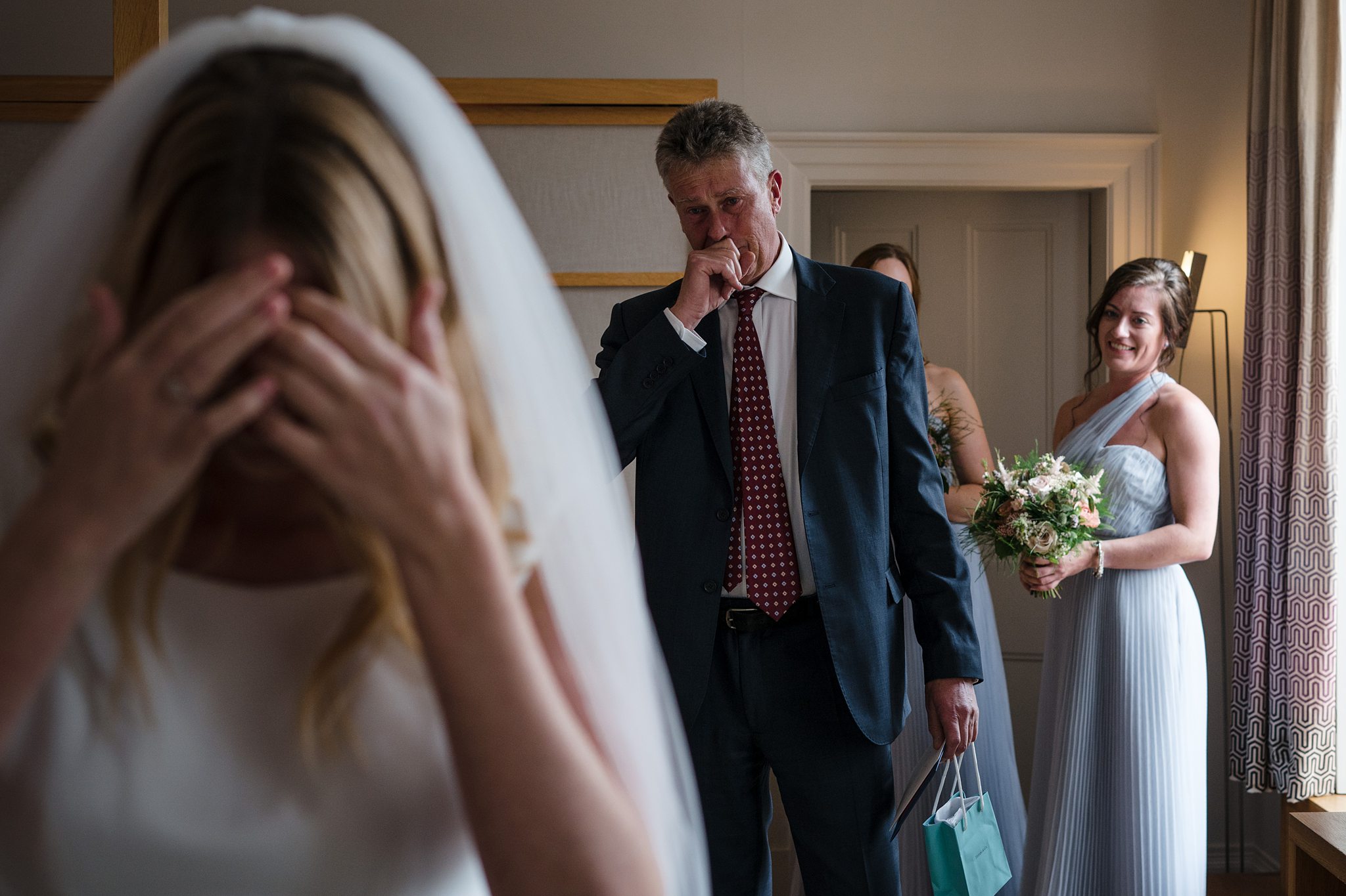 Father wiping tears during emotional first look with bride at Cowley Manor wedding