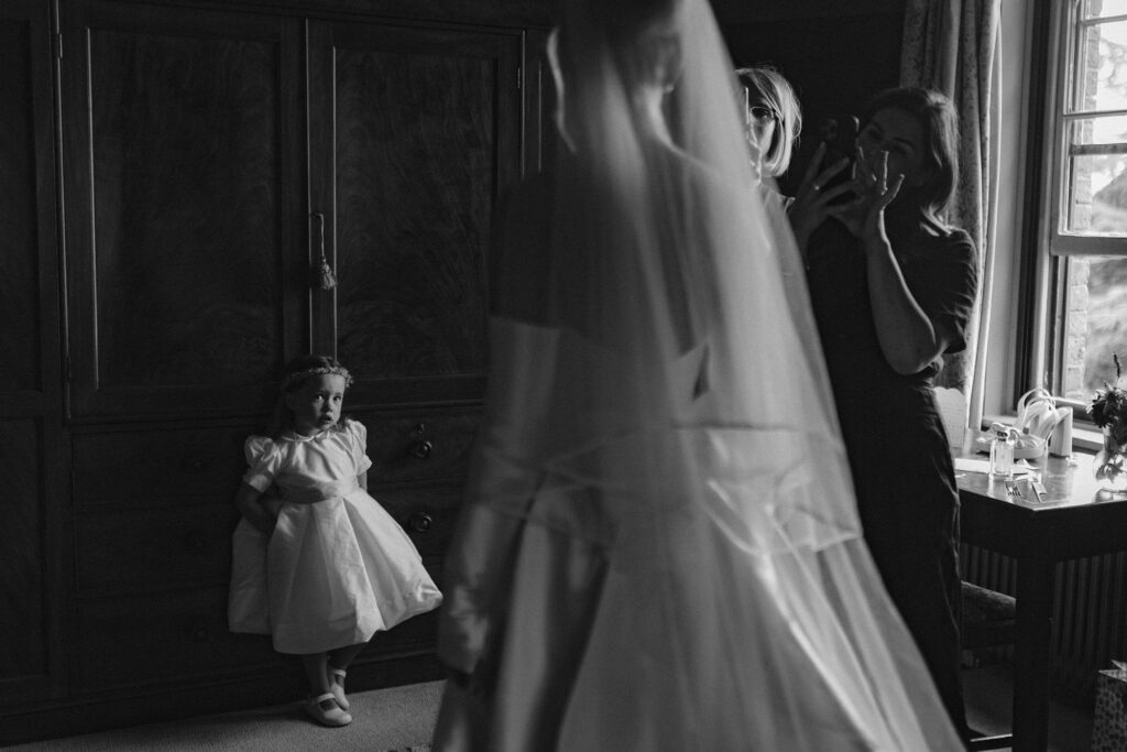 Flower girl watching bride get ready at Pauntley Court wedding