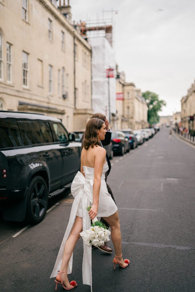 Bride walking through Bath streets in short white dress and heels