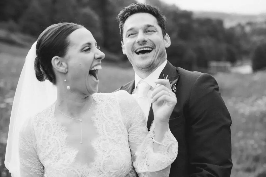 Bride and groom laugh together in candid moment at Prior Park captured in Bath wedding photography