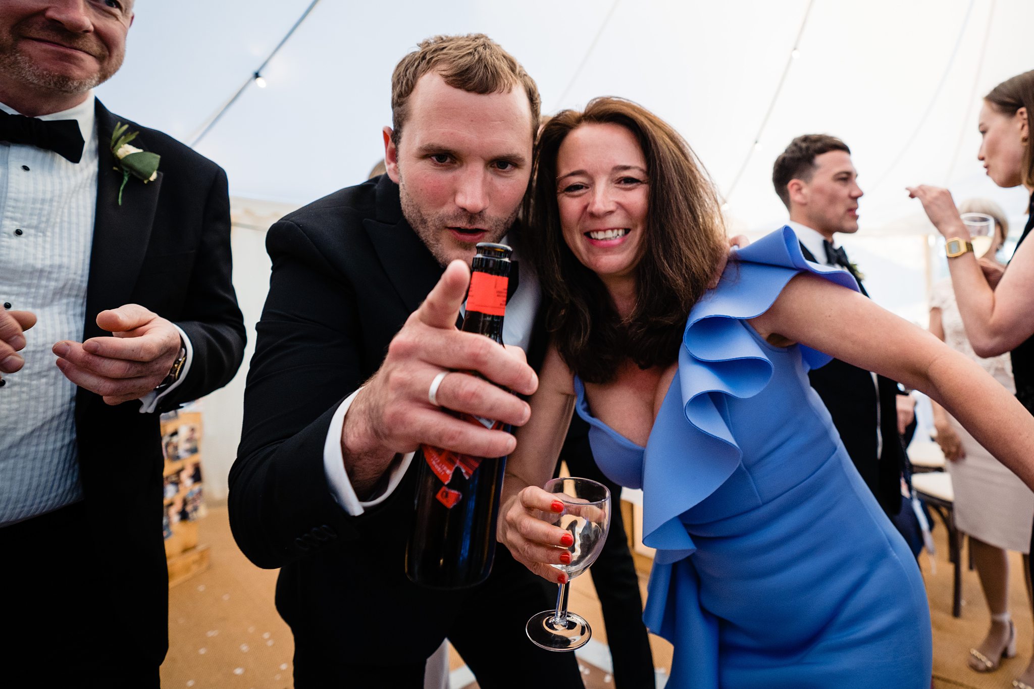 wedding guests smiling and celebrating at marquee reception