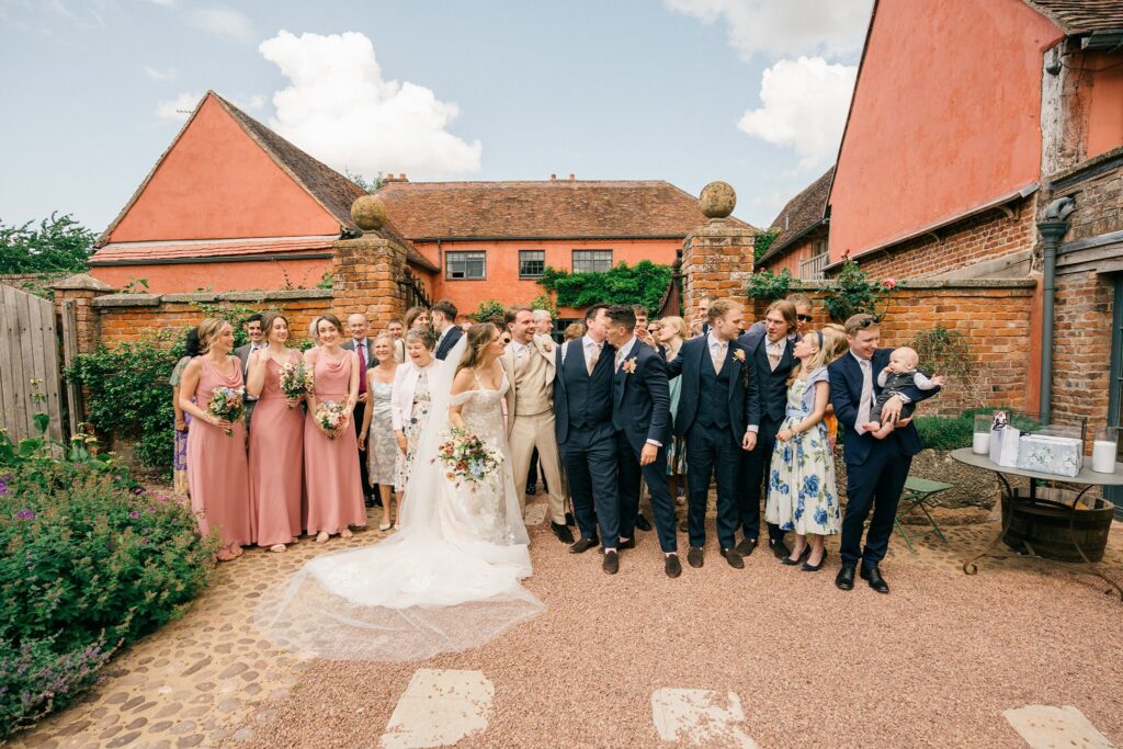 Wedding party gathered outside Pauntley Court, sharing a relaxed moment after the ceremony, captured naturally without posing